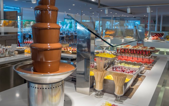 Chocoladefontein van buffet in Buffetzaal met stoelen van Taurus Aquapark resort aan de Costa Brava