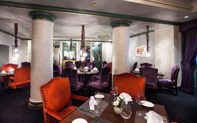 Restaurant met paarse en rode stoelen van hotel Grand Palace stedentrip Riga