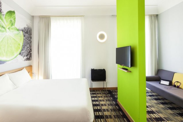 Slaapkamer met groene muur en tv van Hotel Ibis Styles Napoli Garibaldi stedentrip Napels