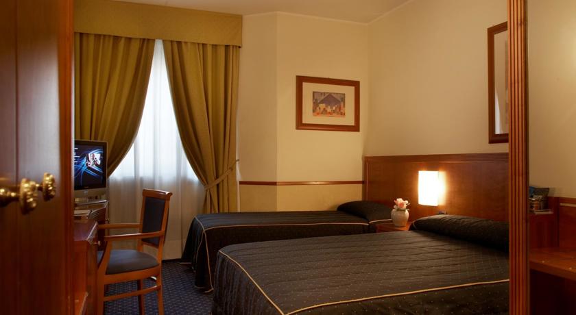 Slaapkamer met een tweepersoonsbed in Pacific Hotel Fortino Turijn
