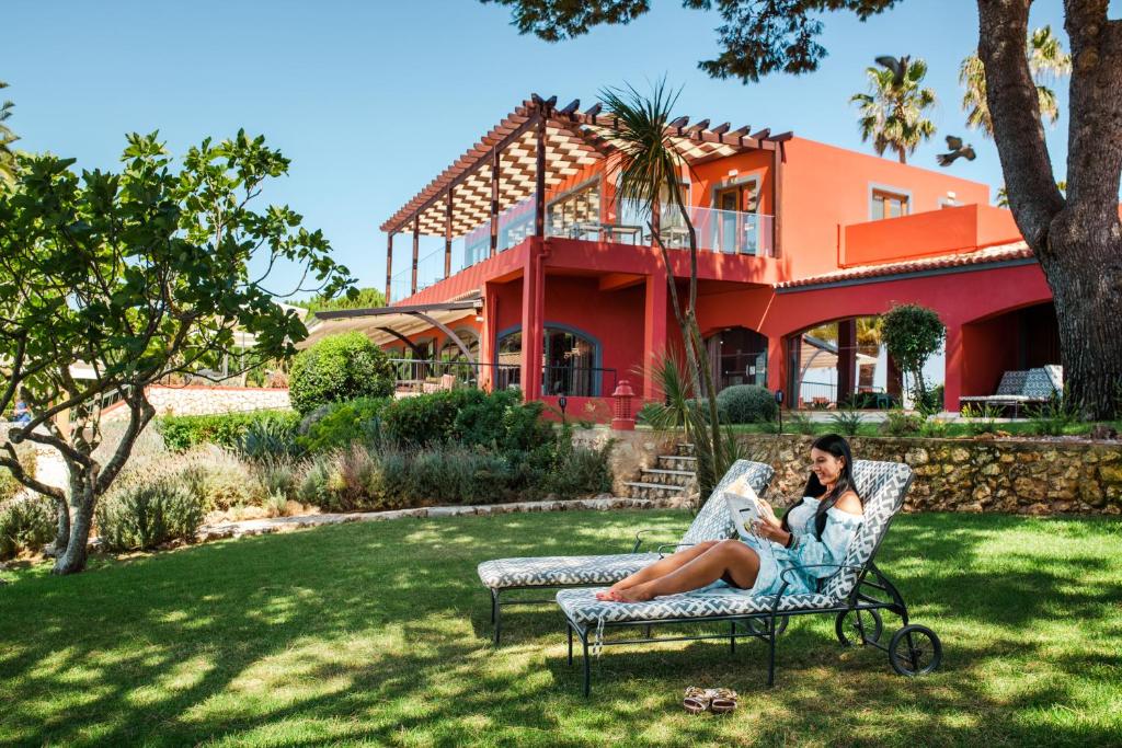 Boutique Hotel Miranda - tuin met ligbedden en hotelgevel
