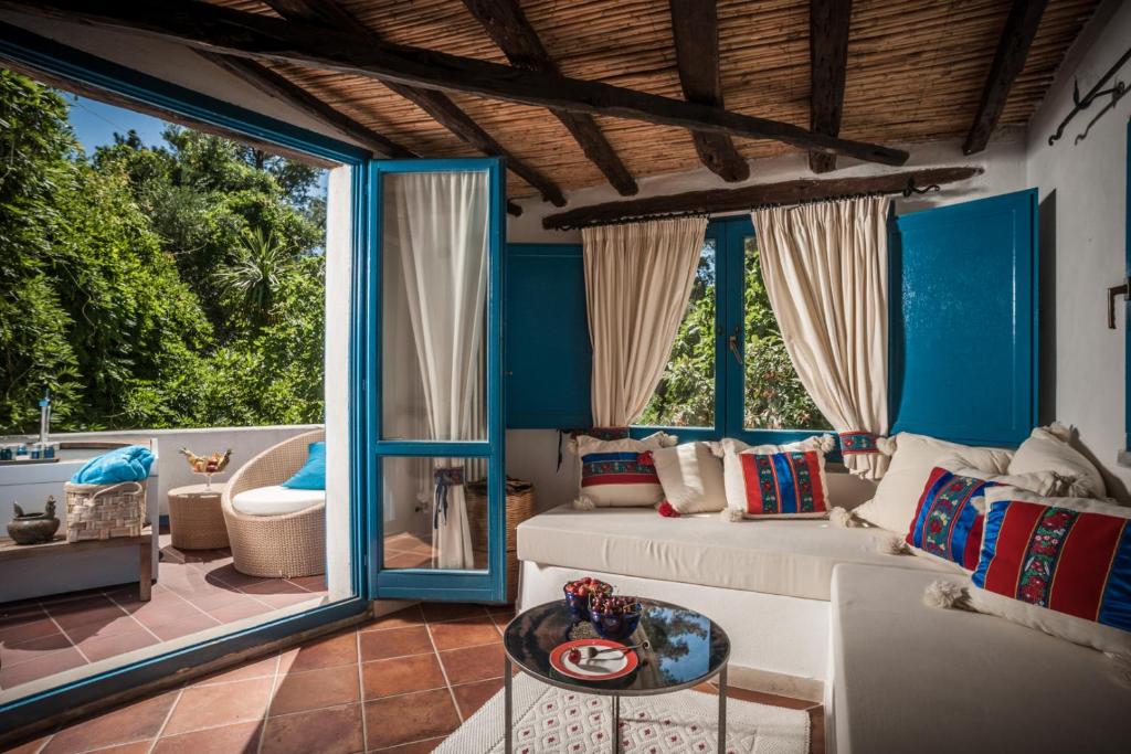 Su Gologone Experience Hotel - suite met blauwe luiken en zithoek
