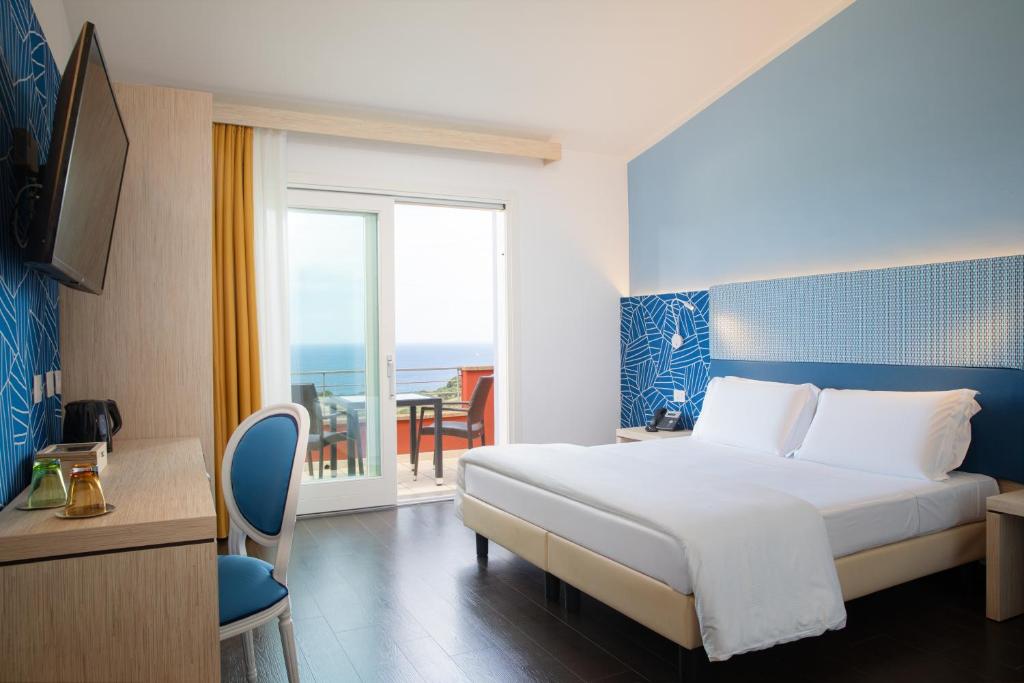 Hotel Bajaloglia Resort - kamer met blauw hoofdbord en balkon