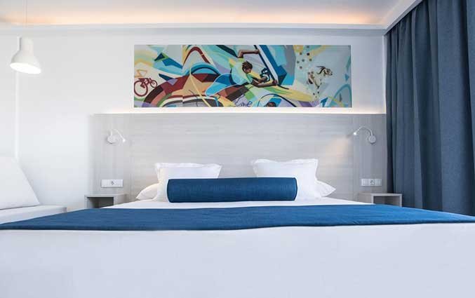 Tweepersoonsbed met blauw dekbed van Appartementen Surfing Colors