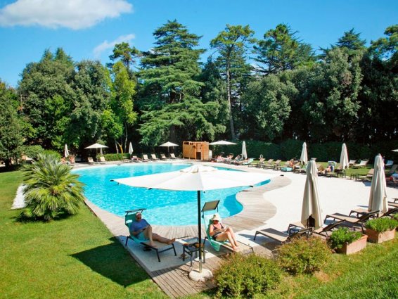 Tuin met zwembad van Resort Borgo Di Colleoli in Toscane