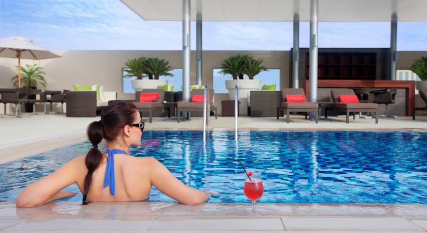Dakterras met zonneterras en zwembad van Hotel Centro Basrha in Dubai
